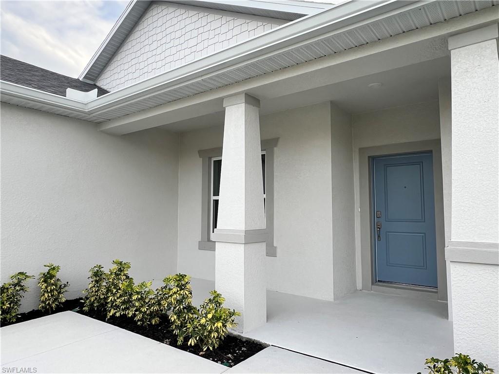 Doorway to property with a porch and stucco siding