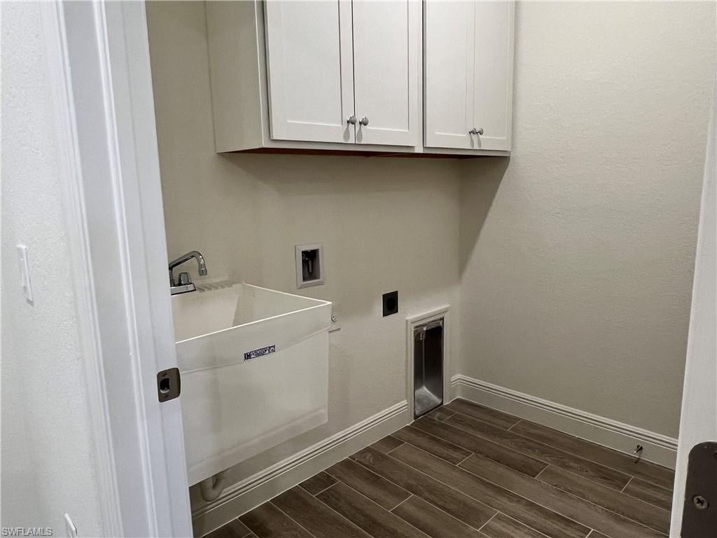 Laundry room featuring wood finish floors, washer hookup, cabinet space, a textured wall, and electric dryer hookup