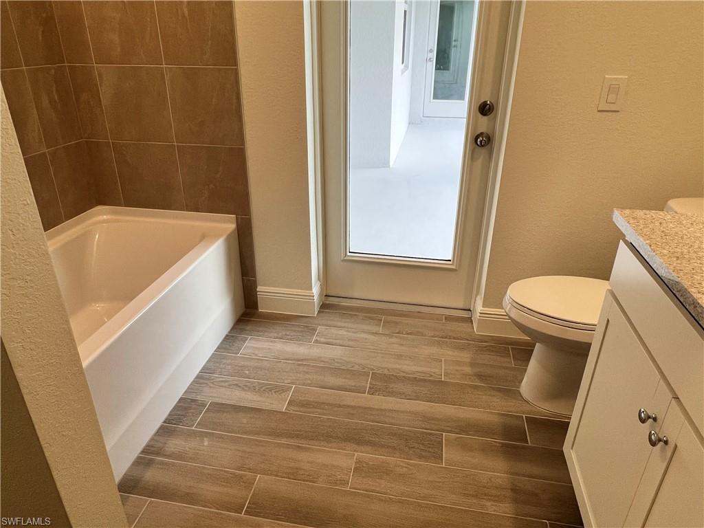 Bathroom featuring vanity, wood tiled floors, and a textured wall