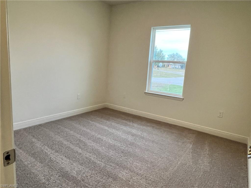 Empty room featuring carpet flooring and baseboards