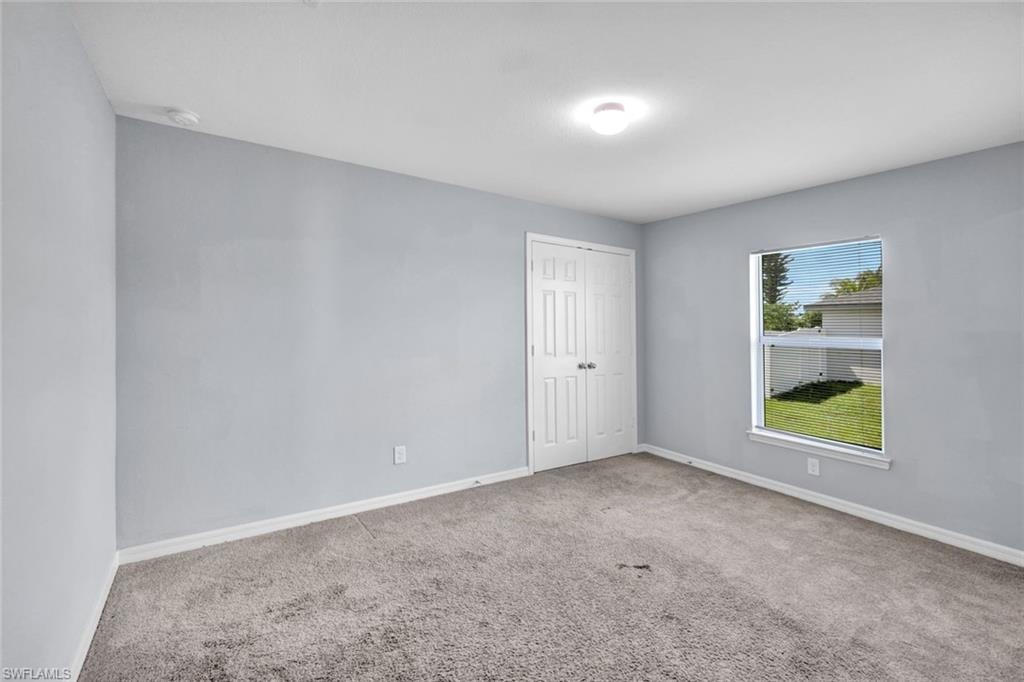 Unfurnished room featuring baseboards and carpet flooring