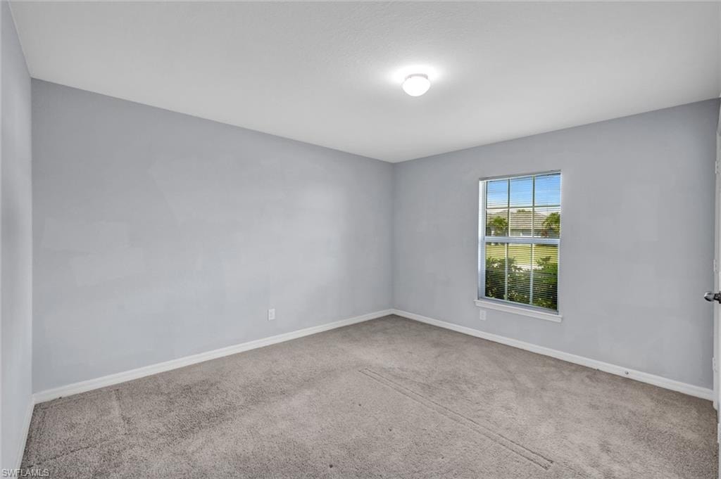 Unfurnished room with baseboards and carpet flooring
