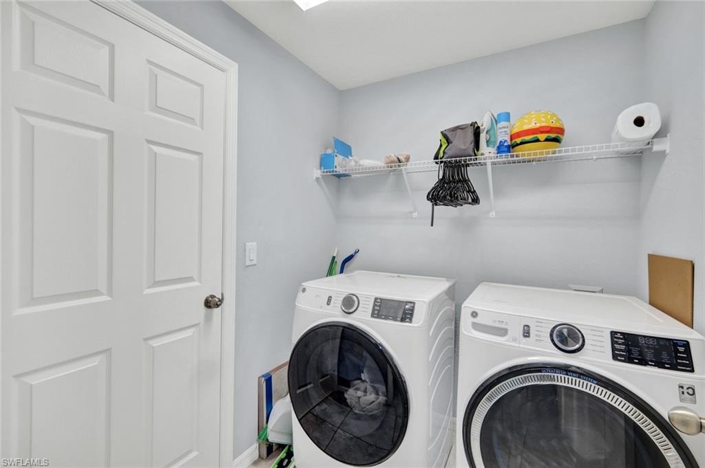 Washroom with washer and dryer and baseboards
