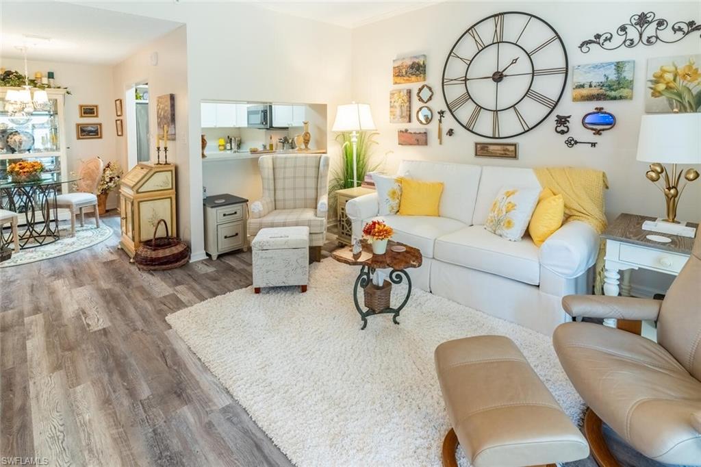 Living room featuring vinly wood-like flooring and a chandelier