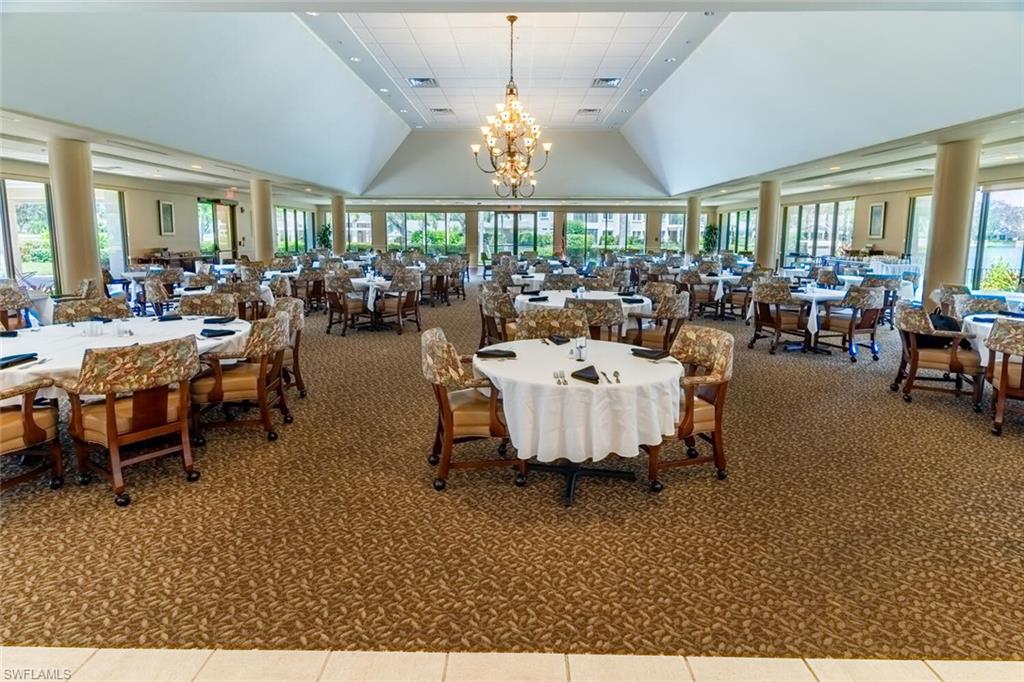 Clubhouse, carpeted dining room featuring high vaulted ceiling and a chandelier