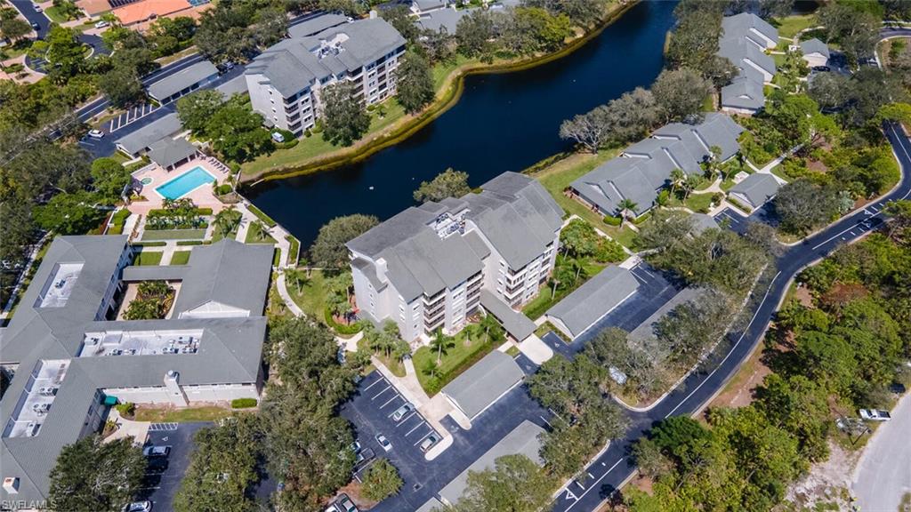 Aerial view of property and surrounding area featuring a nearby body of water and apartment complex