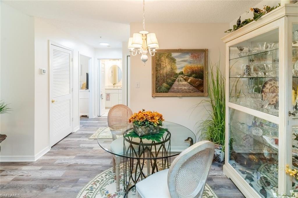 Dining room with vinyl wood-like flooring and a chandelier