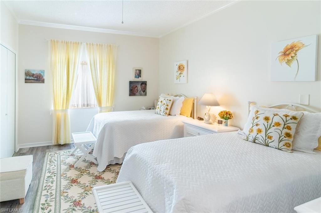 Bedroom with vinyl wood-like flooring and crown molding