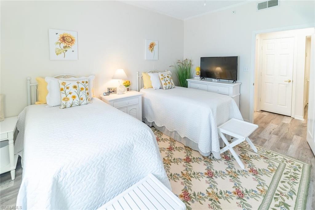 Bedroom withvinyl wood-like flooring and crown molding