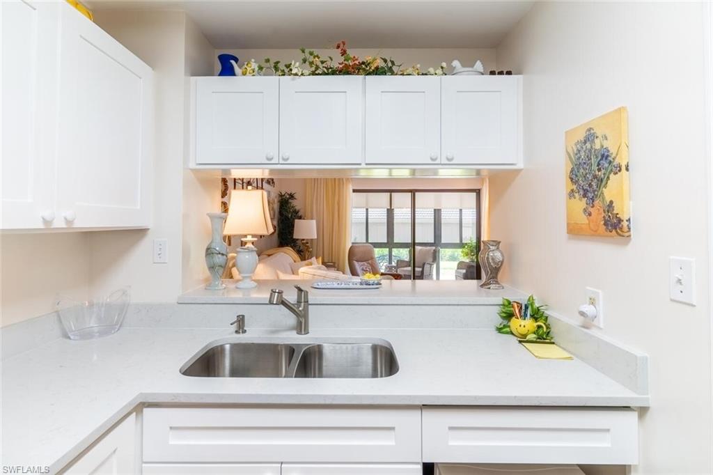 Kitchen with light stone counters and white cabinets