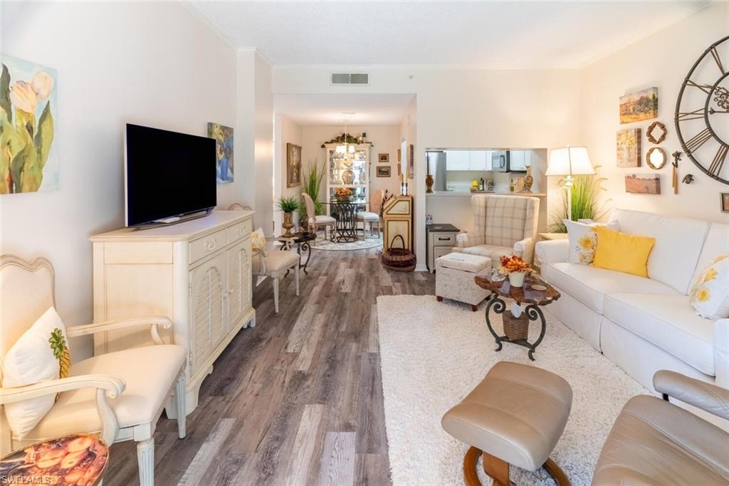 Living area featuring vinyl wood-like flooring and ornamental molding
