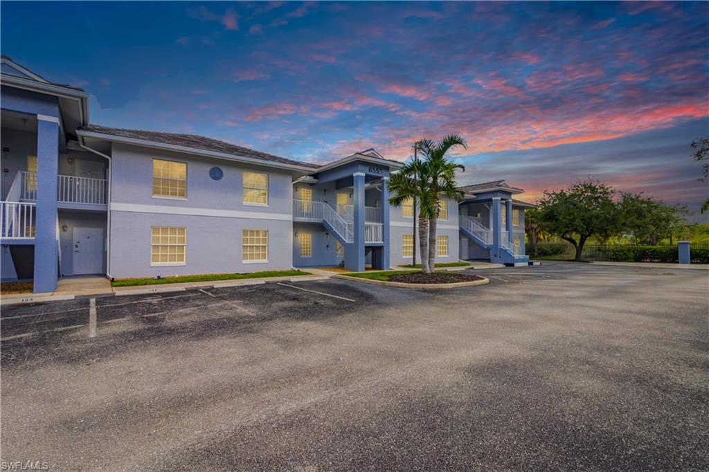 Property at dusk with stairway and uncovered parking