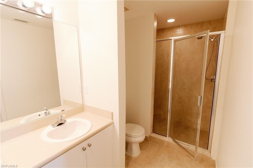 Full bathroom featuring light tile patterned floors, a shower stall, vanity, and recessed lighting