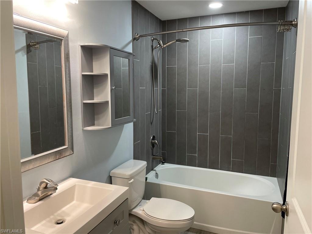 Full bathroom featuring toilet, vanity, and tiled shower / bath