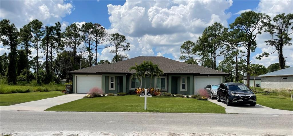 Ranch-style house featuring a front yard and a garage