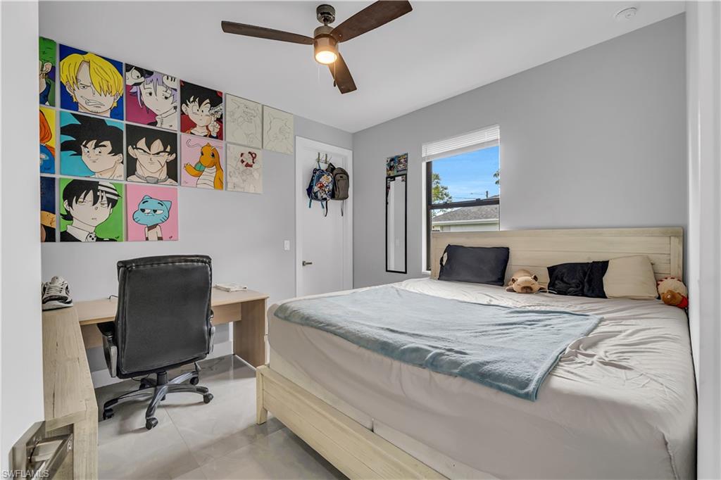 Bedroom with an office area, ceiling fan, and tile patterned flooring