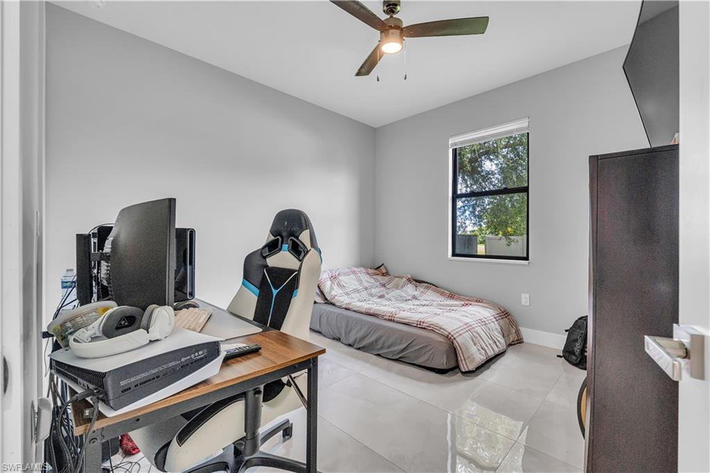 Bedroom with an office area, a ceiling fan, and tile patterned flooring