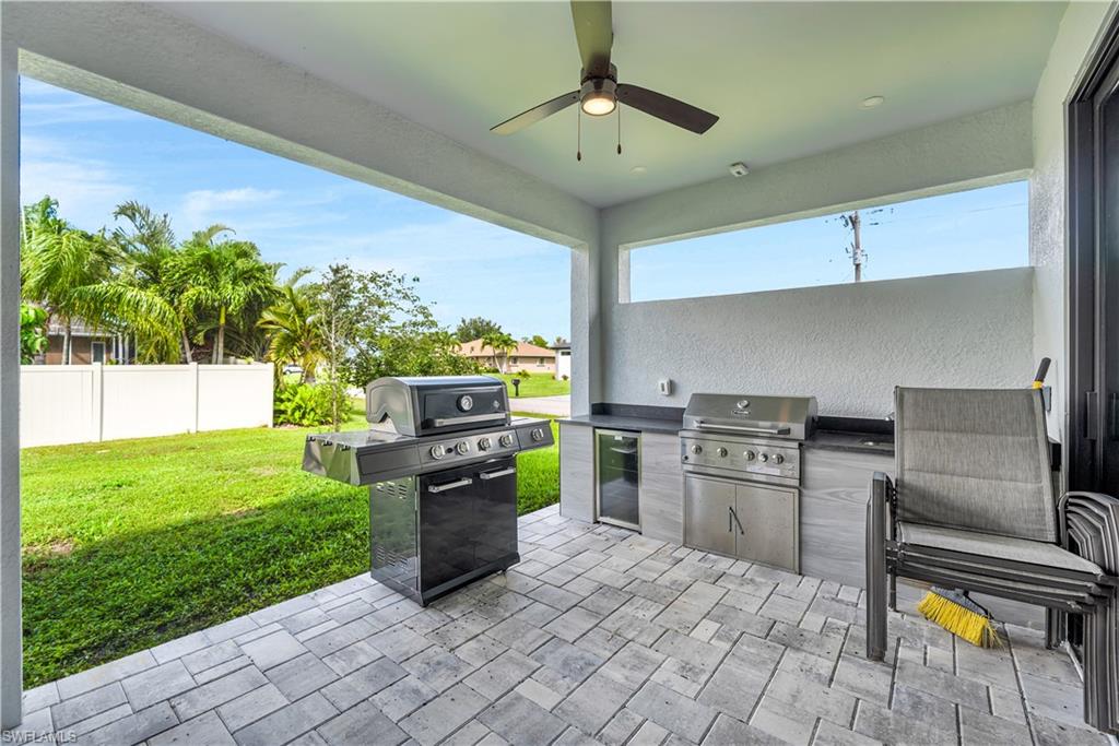 View of patio / terrace with an outdoor kitchen, a ceiling fan, and wine cooler