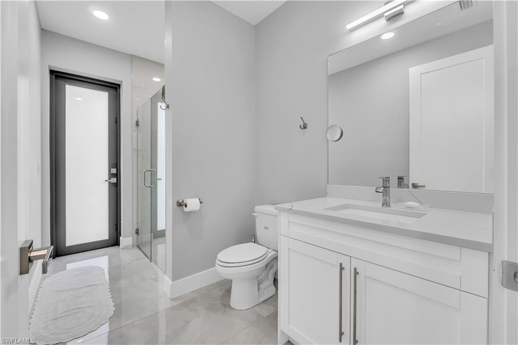 Full bathroom with vanity, a shower stall, recessed lighting, and light tile patterned flooring