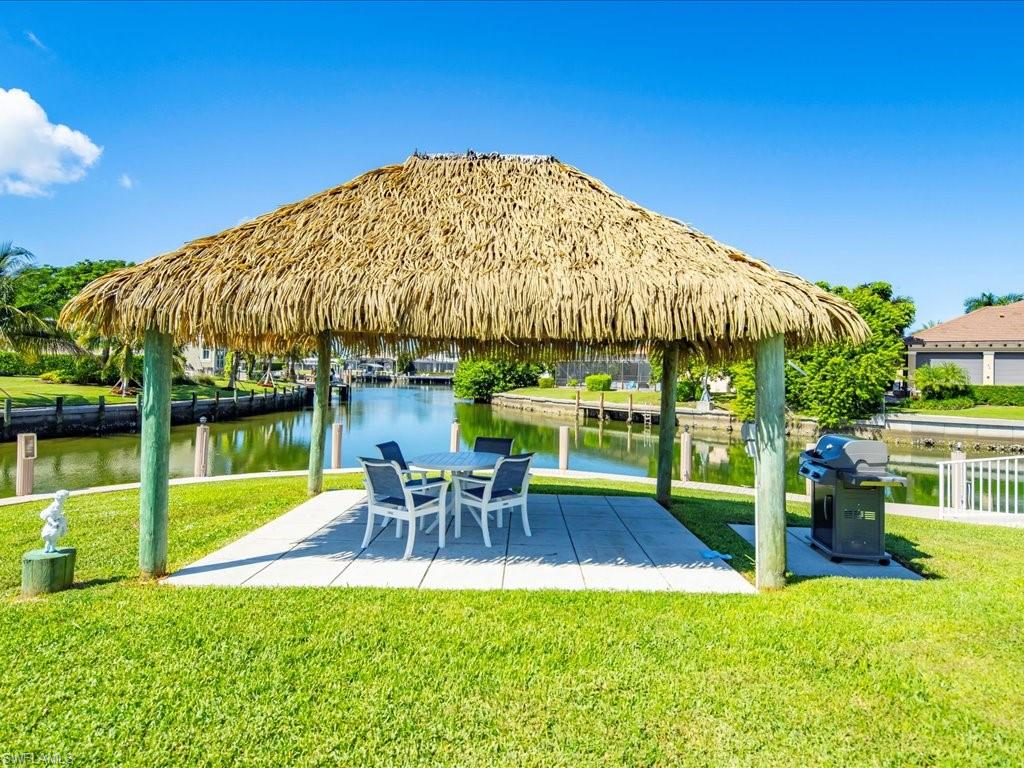 View of home's community featuring a yard, a water view, and a patio