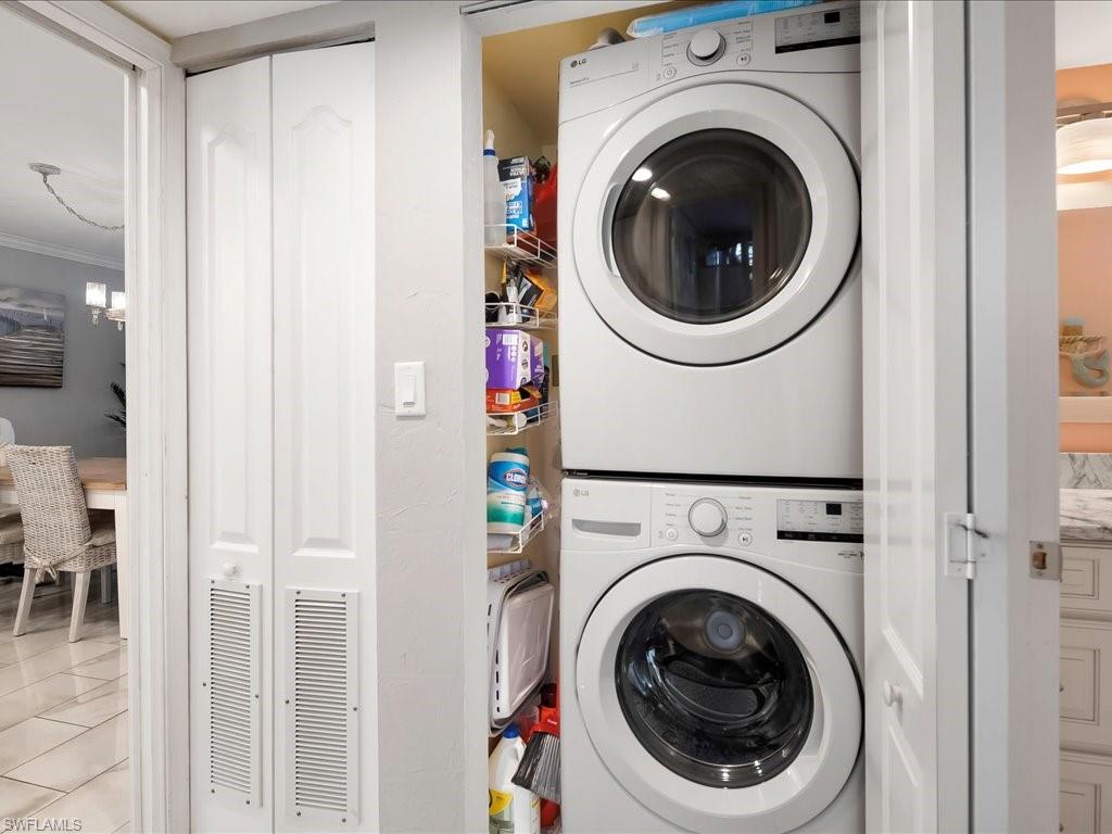 Washroom featuring stacked washer / dryer and tile patterned floors