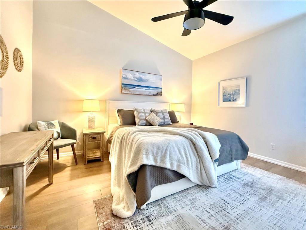 Bedroom featuring vaulted ceiling, light wood-style flooring, and ceiling fan