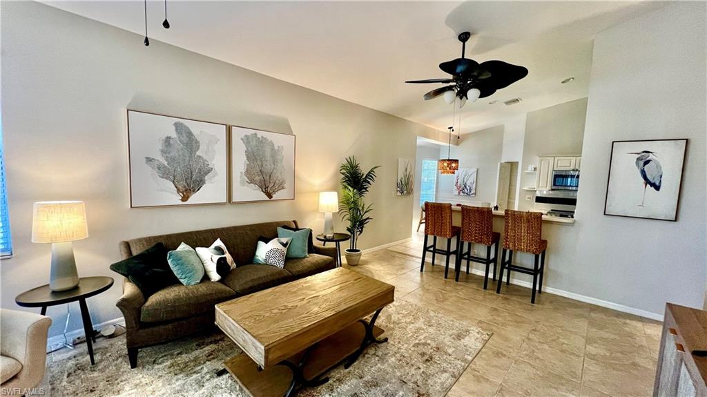 Living area with ceiling fan and high vaulted ceiling