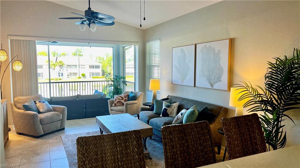 Living area featuring light tile patterned floors, plenty of natural light, ceiling fan, and vaulted ceiling