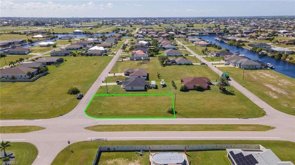 Aerial view of residential area with a large body of water and property boundaries highlighted