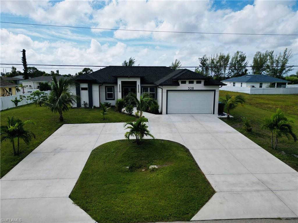 Ranch-style home featuring stucco siding, concrete driveway, a garage, and a shingled roof