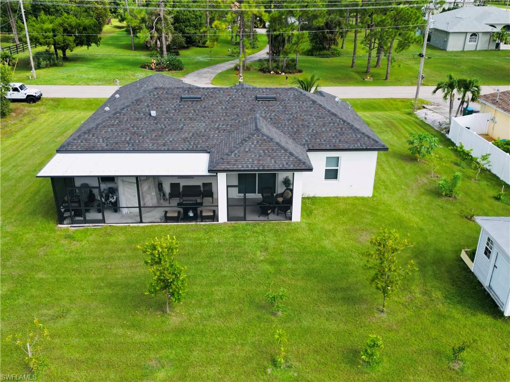 Rear view of house with a lawn and stucco siding