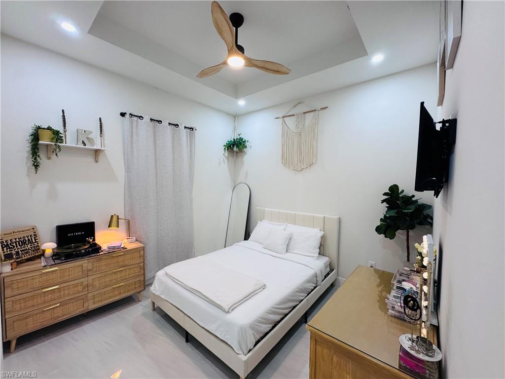 Bedroom featuring a raised ceiling and a ceiling fan