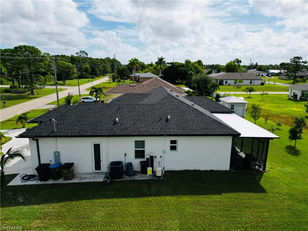 Rear view of house with a lawn, stucco siding, and a patio area