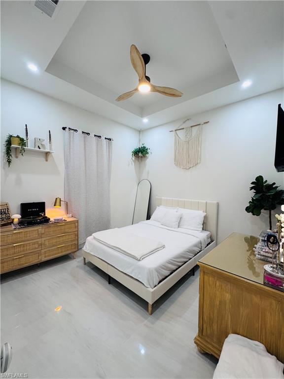Bedroom featuring a tray ceiling, recessed lighting, and ceiling fan