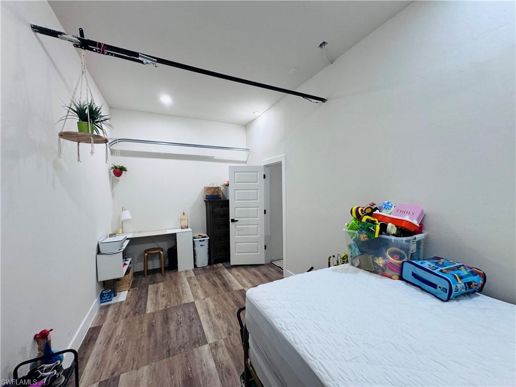 Bedroom with wood finished floors and baseboards