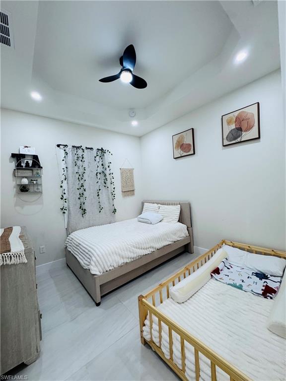 Bedroom featuring a raised ceiling, a ceiling fan, and recessed lighting