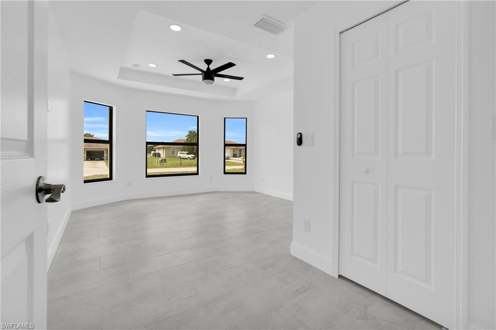 Unfurnished room with a raised ceiling, recessed lighting, and ceiling fan