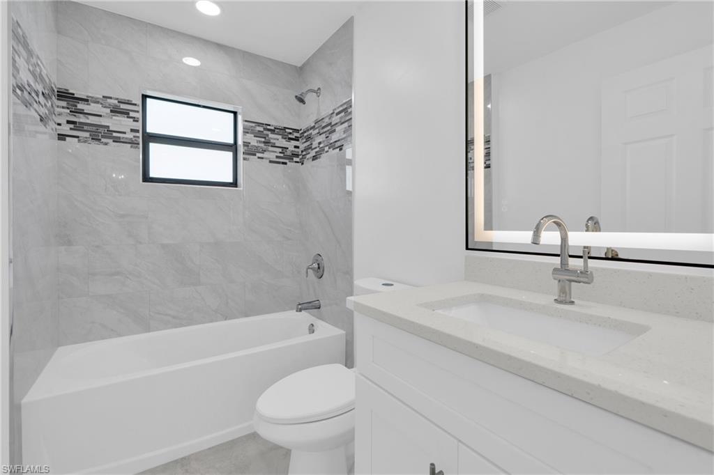 Bathroom with  shower combination, vanity, and recessed lighting
