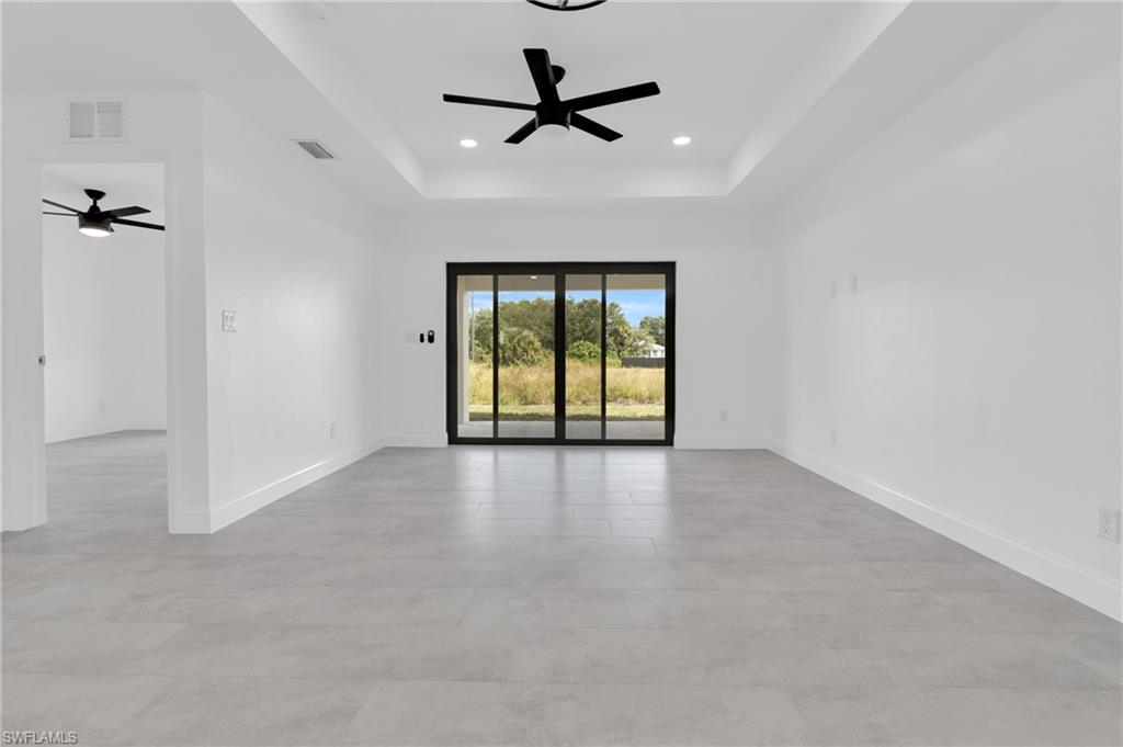 Spare room with a tray ceiling, recessed lighting, and a ceiling fan