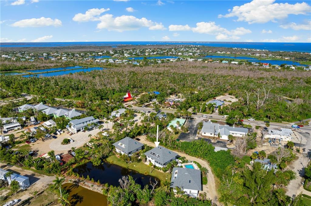 Aerial view of property's location featuring a nearby body of water and nearby suburban area
