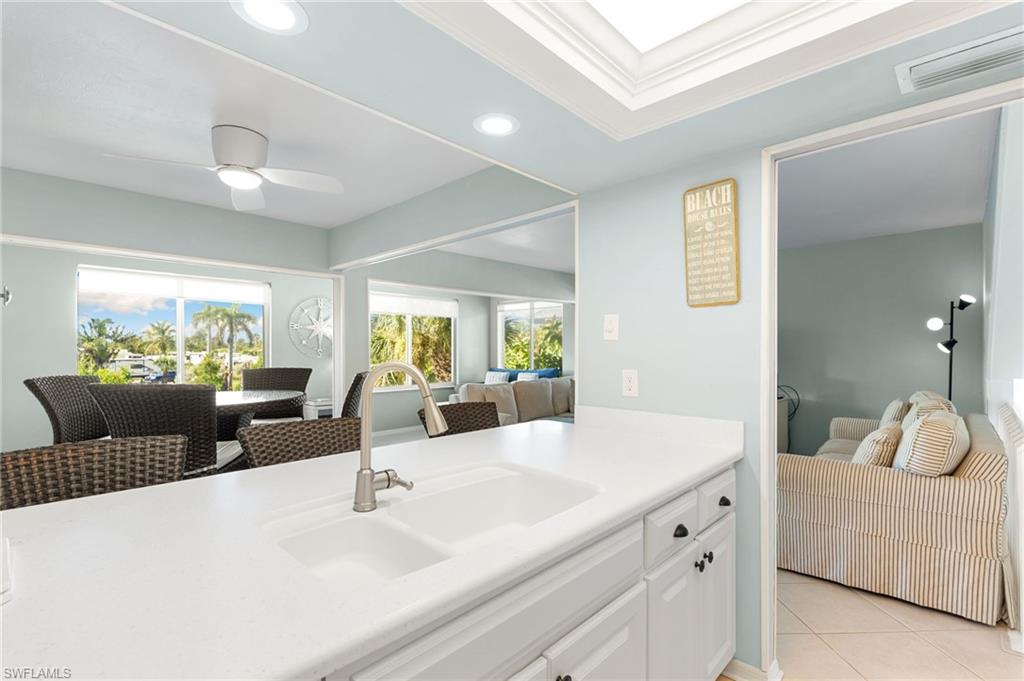Kitchen with white cabinets, recessed lighting, light tile patterned floors, open floor plan, and ceiling fan