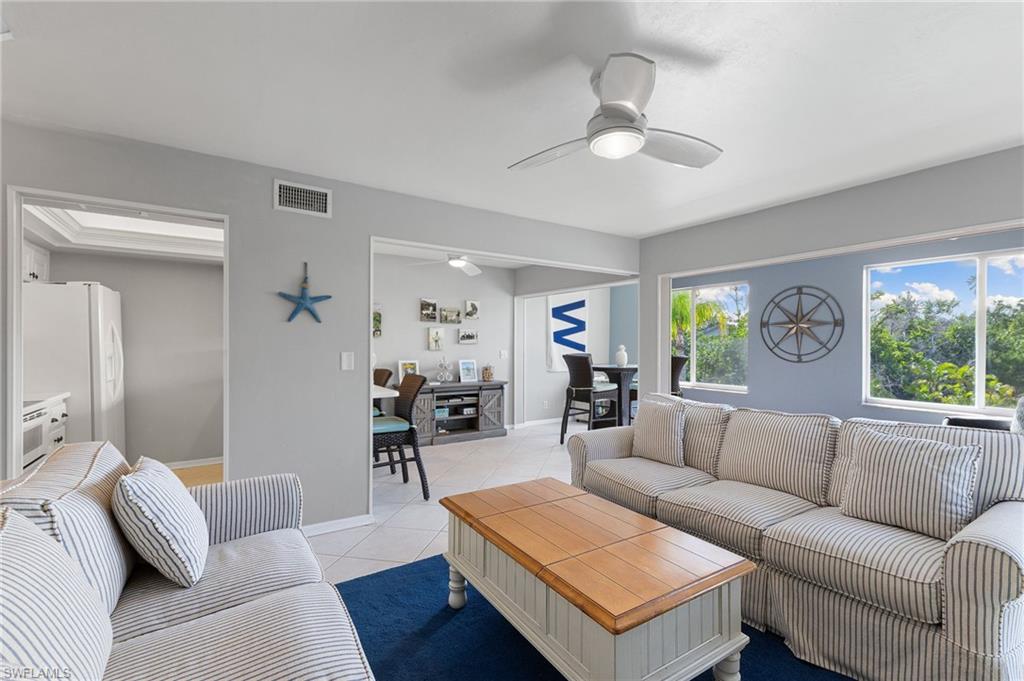 Living room with light tile patterned flooring and a ceiling fan