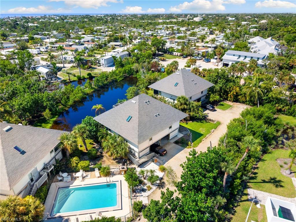 Aerial view of residential area featuring a pool area and a large body of water