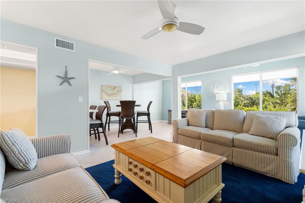 Living area featuring tile patterned floors and a ceiling fan