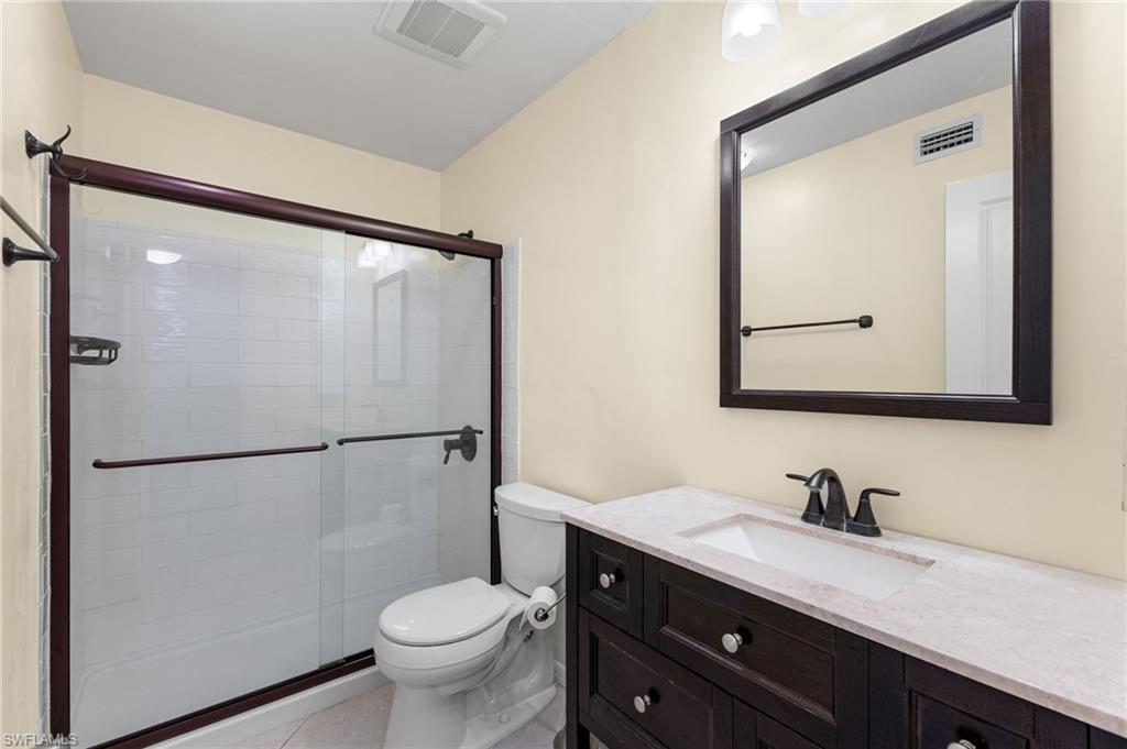 Bathroom with vanity, a shower stall, and light tile patterned floors
