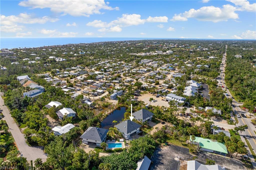 Aerial view of property and surrounding area featuring a large body of water and nearby suburban area