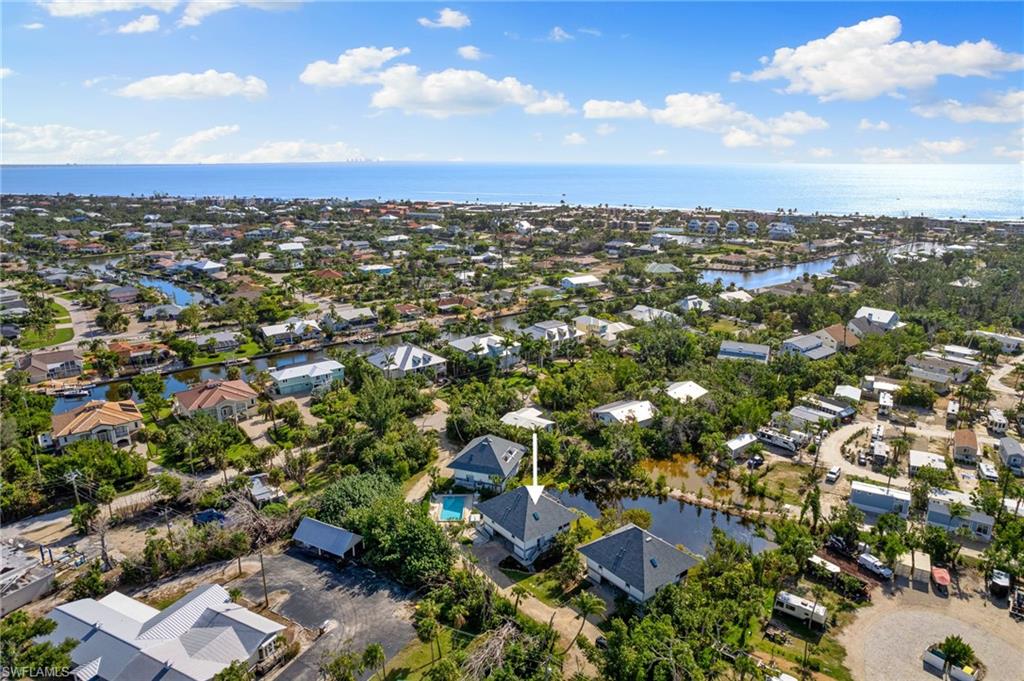Aerial view of property's location featuring a nearby body of water and nearby suburban area
