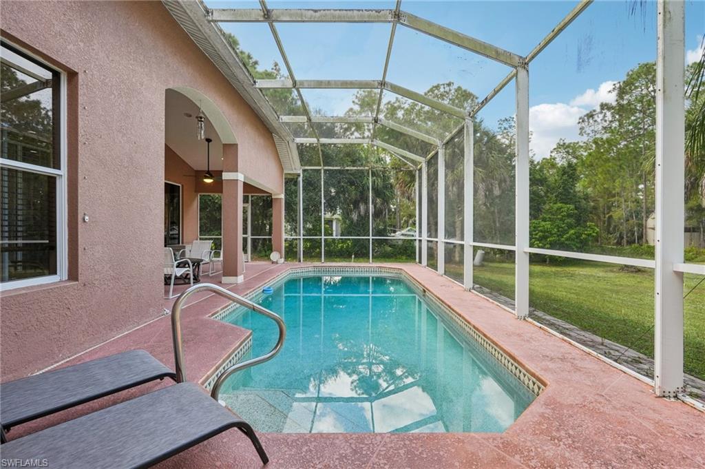 Swimming pool featuring a sunroom, a patio area, a lanai, a yard, and ceiling fan
