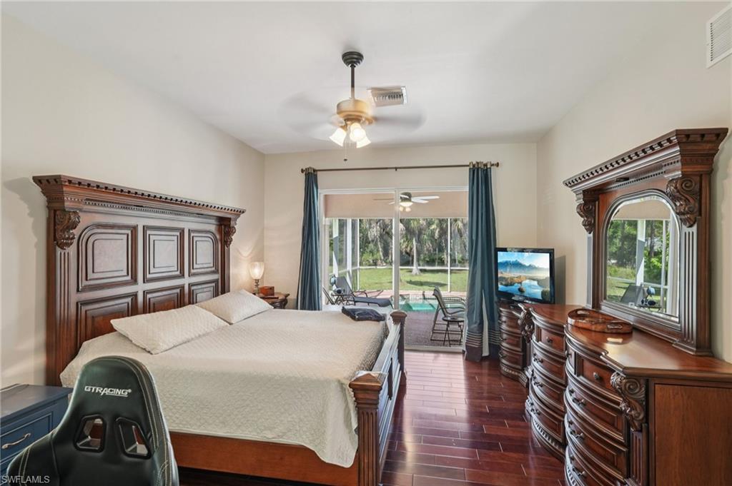 Bedroom with dark wood-style floors, access to outside, and ceiling fan