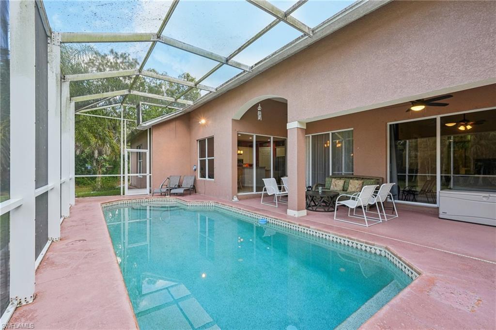 Outdoor pool featuring a patio area, a sunroom, glass enclosure, and ceiling fan